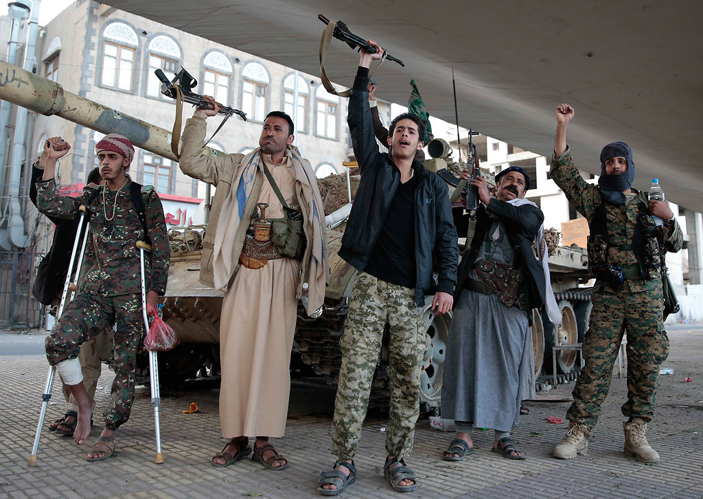 Houthi Shiite fighters chant slogans as they guard a street leading to the residence of former Yemeni President Ali Abdullah Saleh